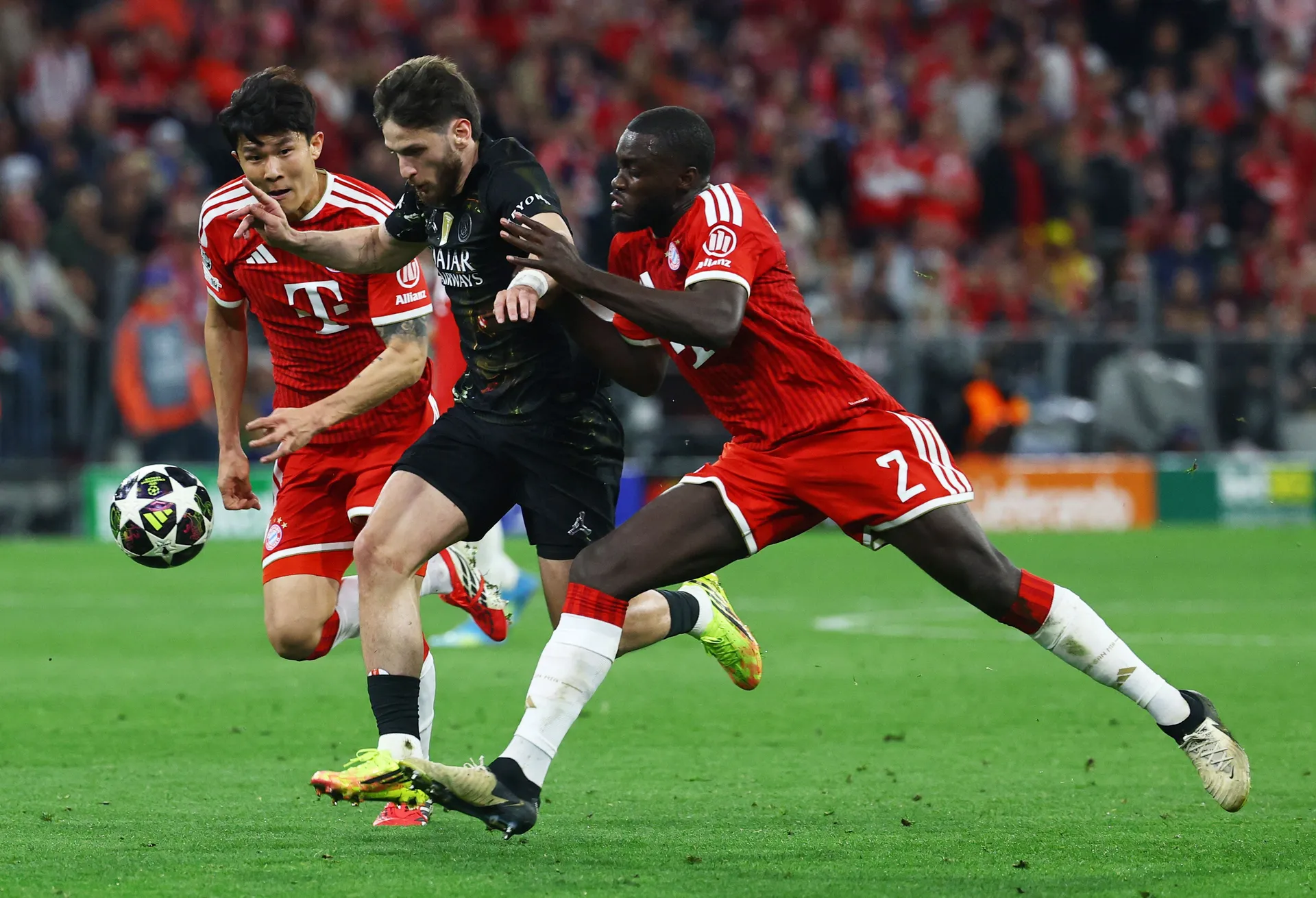 Soccer Football - UEFA Champions League - Semi Final - Second Leg - Bayern Munich v Paris St Germain - Allianz Arena, Munich, Germany - May 6, 2026 Paris St Germain's Khvicha Kvaratskhelia in action with Bayern Munich's Kim Min-jae and Dayot Upamecano REU