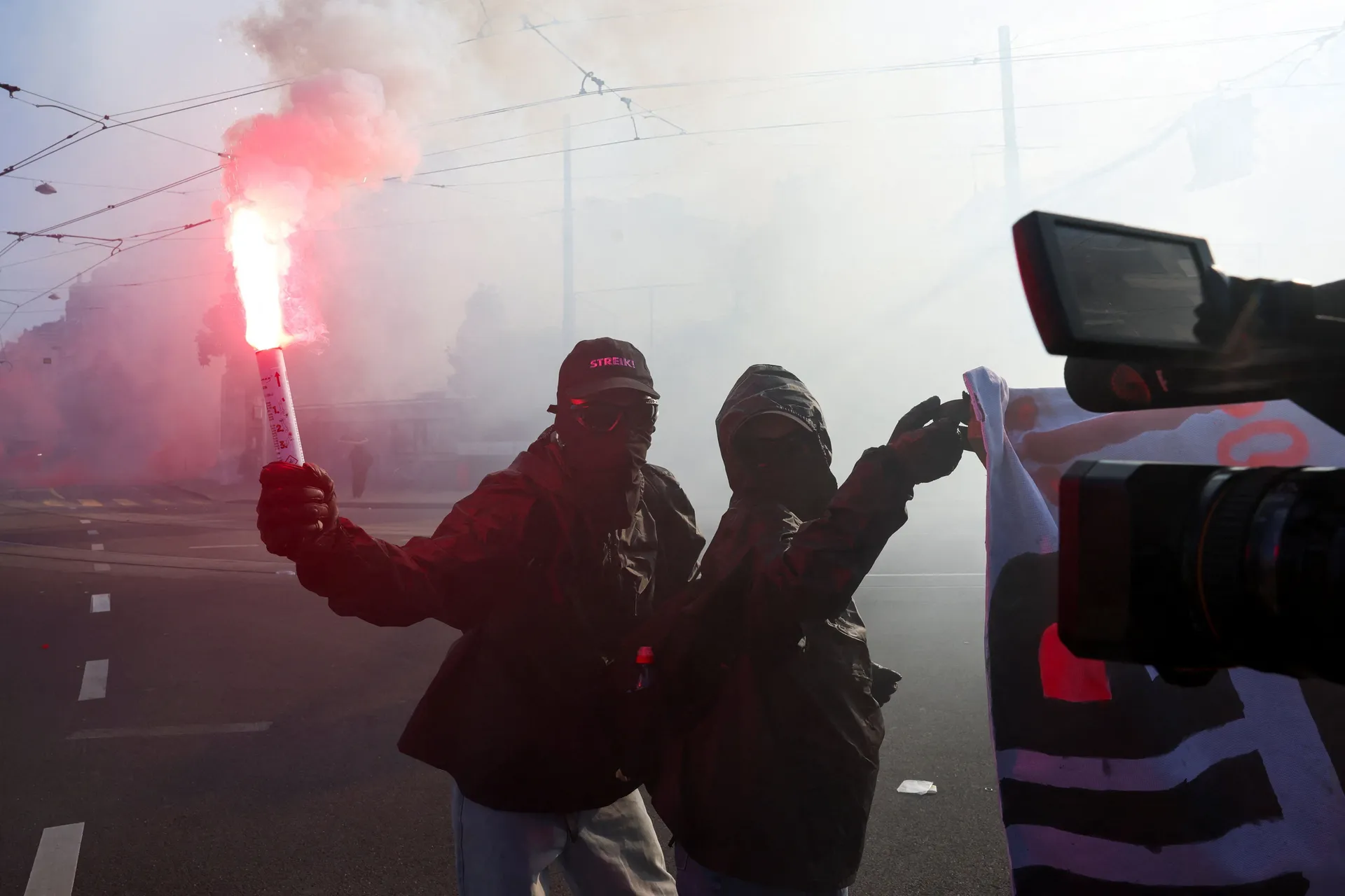 Demonstrators hold a banner and a flare, during a protest against the upcoming G7 summit in Evian-les-Bains in France, in Geneva, Switzerland, June 14, 2026. REUTERS/Denis Balibouse