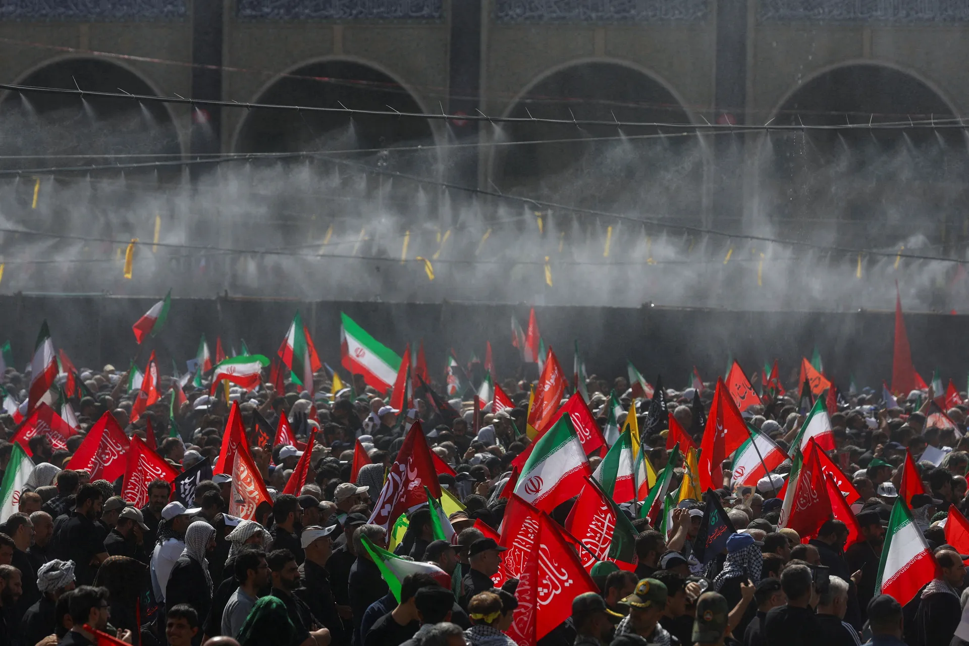 Water is sprayed on people attending a public farewell ceremony to pay their respects to late Supreme Leader Ayatollah Ali Khamenei, who was killed on February 28 in Israeli and U.S. airstrikes, at the Imam Khomeini Grand Mosalla, in Tehran, Iran July 4, 