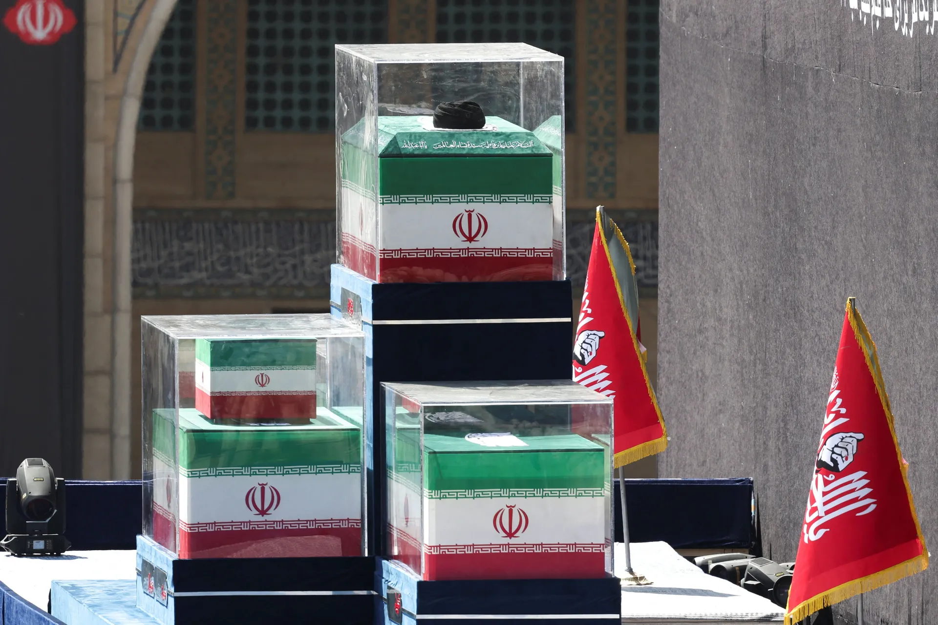 A turban is placed over the coffin of Iran's late Supreme Leader Ayatollah Ali Khamenei, near the coffins of Khamenei's family members in the colours of Iranian flags on the stage, as people gather for a public farewell ceremony to pay their respects to l