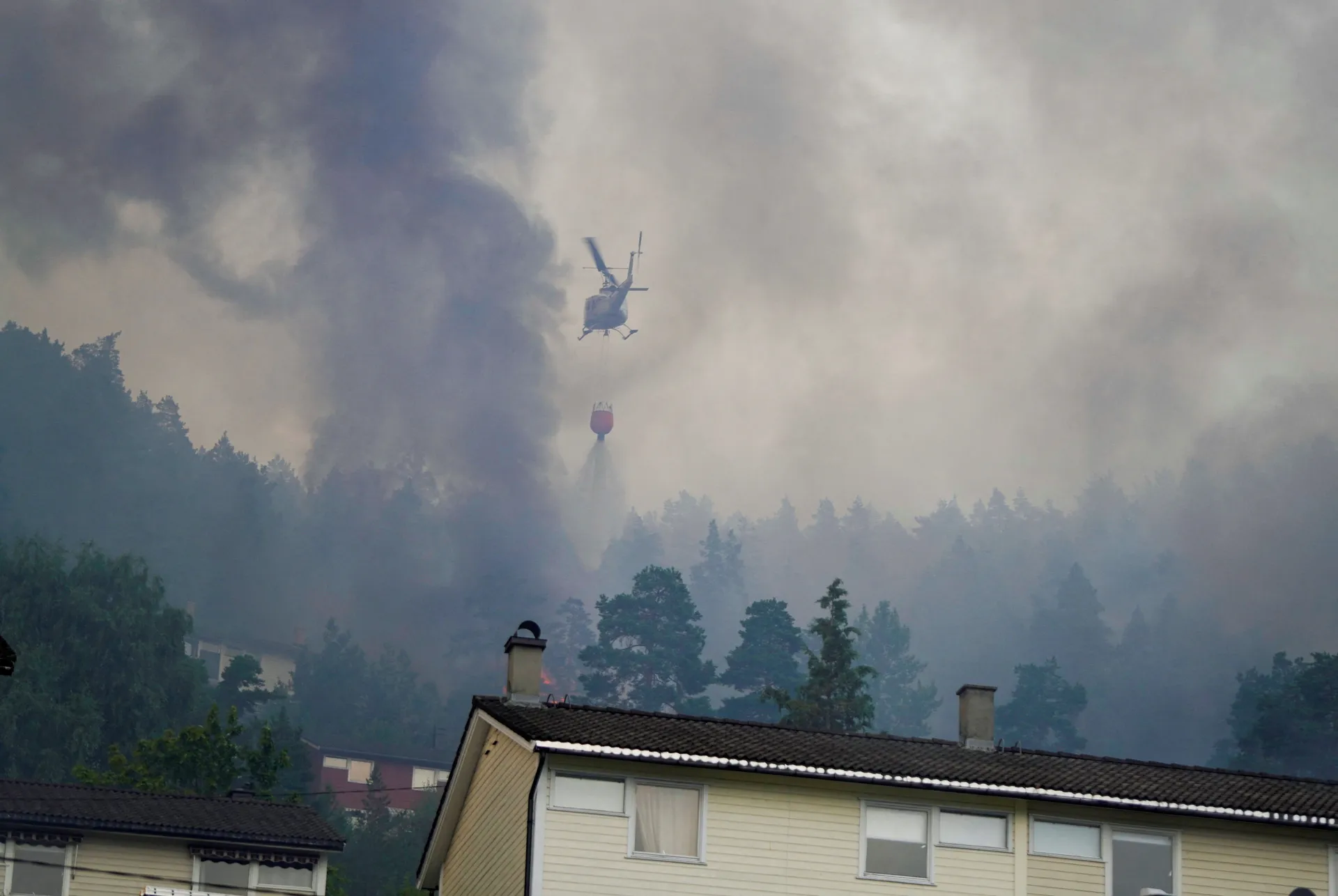 Smoke rises from a large fire that has spread from terraced houses in Krokstadelva, Drammen municipality, Norway, July 17, 2026. More than 50 homes were destroyed by fire on Friday near the city of Drammen in southern Norway as firefighters battled to con