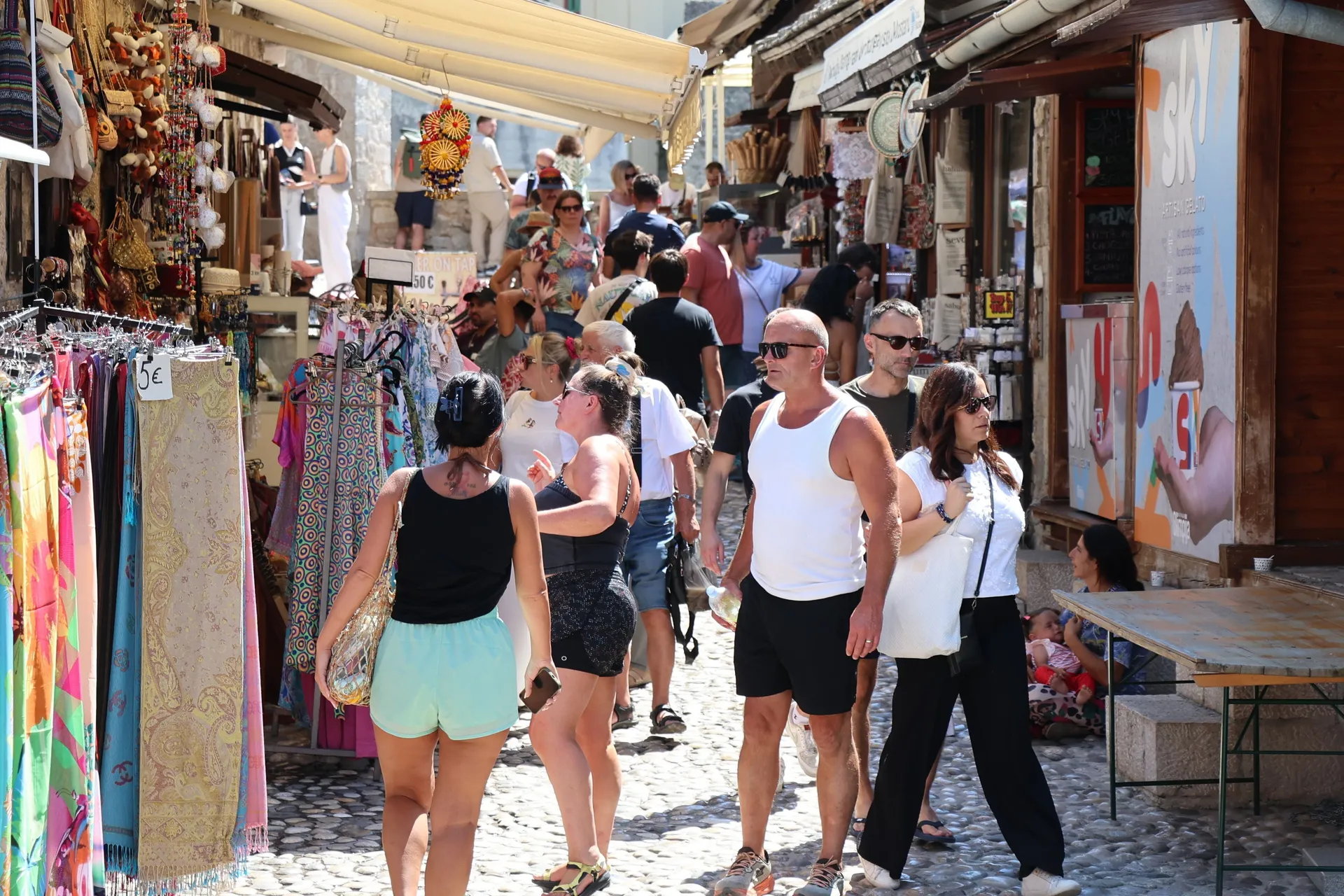 MOSTAR, 18. srpnja (FENA) - Unatoč visokim ljetnim temperaturama zraka koje su i ovog vikenda pogodile Mostar, stara gradska jezgra i područje oko Starog mosta i dalje su među najposjećenijim lokacijama za domaće i strane turiste.  (Foto FENA/Mateo Marino