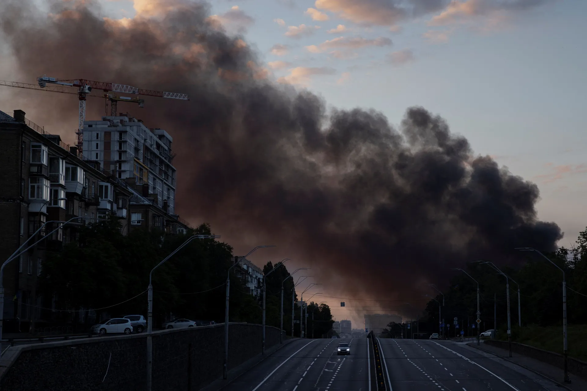 A column of smoke rises over the city as a car drives on a highway following Russian missile strikes, amid Russia’s attack on Ukraine, in Kyiv, Ukraine, July 19, 2026. REUTERS/Thomas Peter