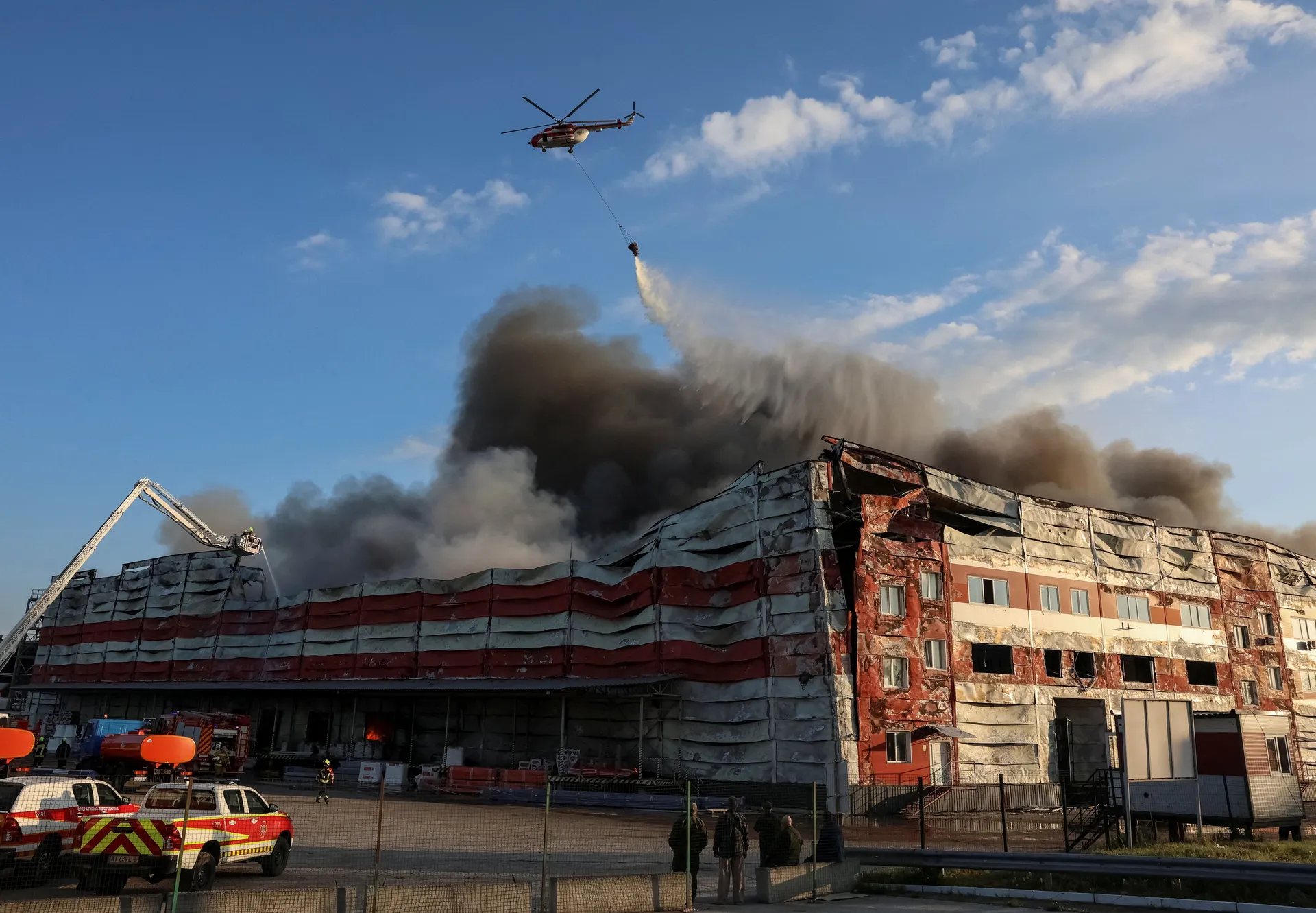 A firefighting helicopter drops water over the site of a Russian missile strike, amid Russia's attack on Ukraine, in Kyiv region, Ukraine July 19, 2026. REUTERS/Anatolii Stepanov