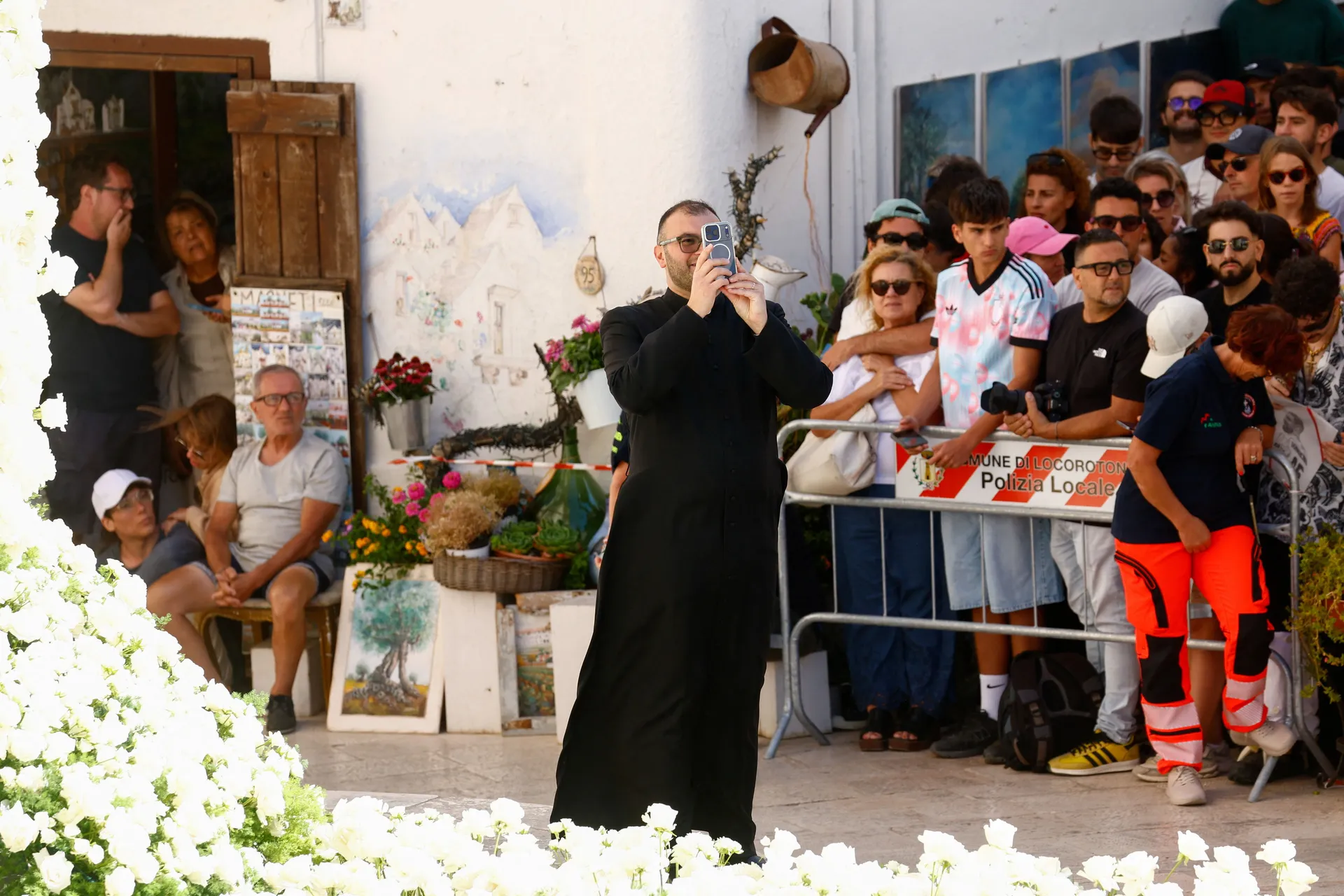 A priest photographs floral decorations ahead of the wedding of Manchester City goalkeeper Gianluigi Donnarumma and Alessia Elefante at the Chiesa Madre di San Giorgio Martire in Locorotondo, Italy, July 24, 2026. REUTERS/Alessandro Garofalo