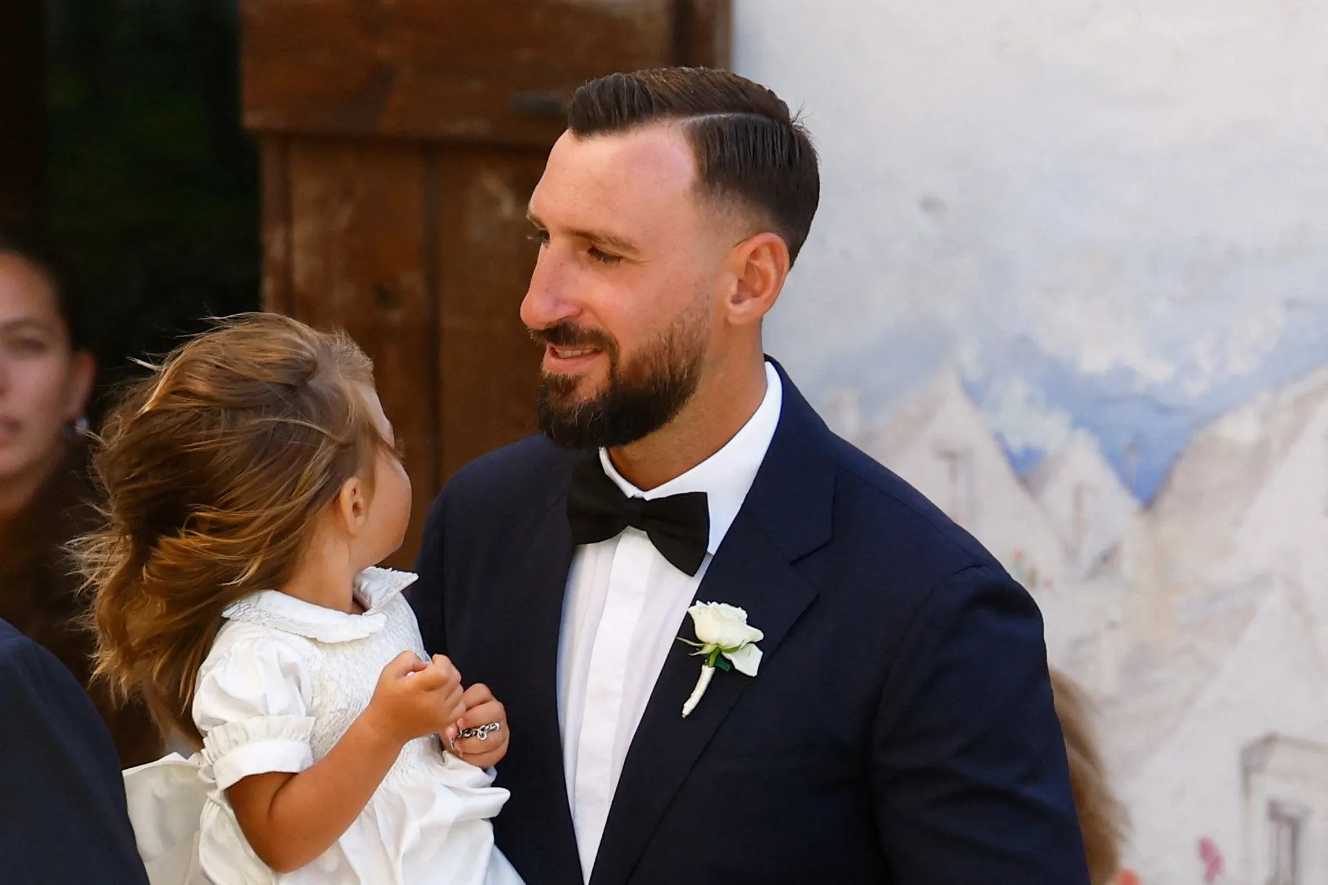 Antonio Donnarumma, brother of groom, Manchester City goalkeeper and Italy captain Gianluigi Donnarumma, holds his daughter as he arrives for the wedding ceremony of Donnarumma and Alessia Elefante at the Chiesa Madre di San Giorgio Martire in Locorotondo