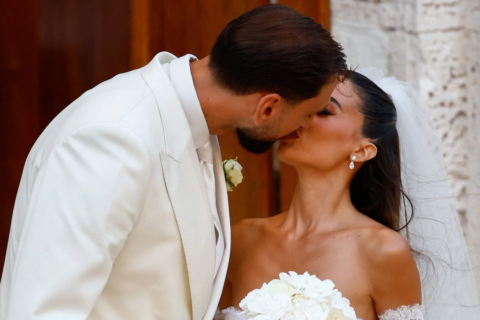 Manchester City goalkeeper and Italy captain Gianluigi Donnarumma kisses his wife Alessia Elefante following their wedding ceremony at the Chiesa Madre di San Giorgio Martire in Locorotondo, Italy, July 24, 2026. REUTERS/Alessandro Garofalo      TPX IMAGE