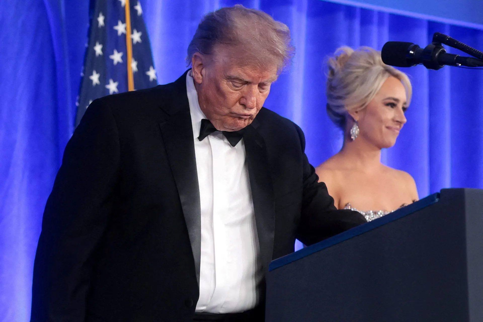 U.S. President Donald Trump, with incoming White House Correspondents' Association (WHCA) President and Fox News Senior White House Correspondent Jacqui Heinrich, takes the lectern to deliver remarks at the WHCA Dinner, which was rescheduled from April af