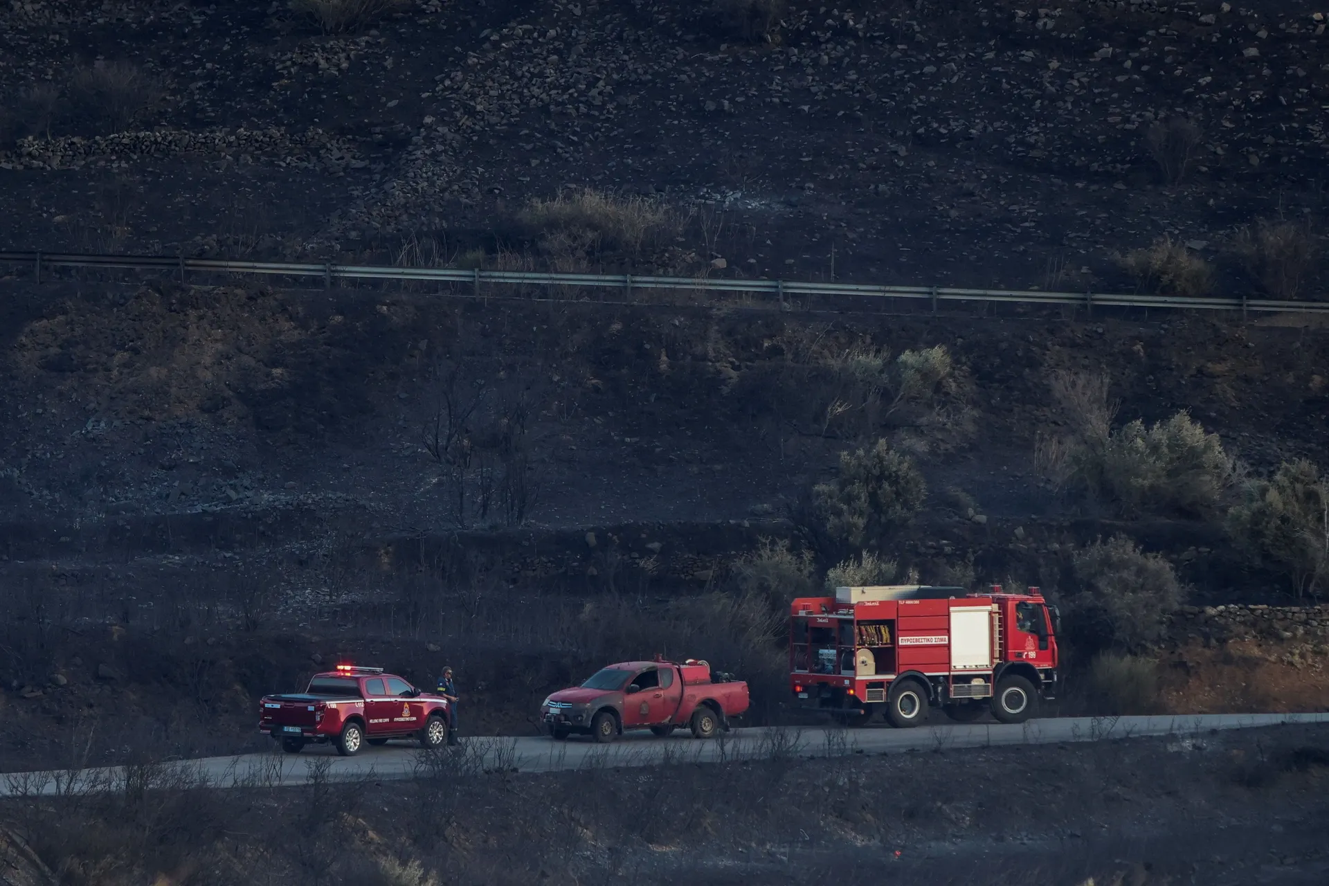 Firefighting vehicles sit parked next to a damaged firefighting car as a wildfire burns next to the village of Krya Vrysi on the island of Crete, Greece, July 29, 2026. REUTERS/Stringer