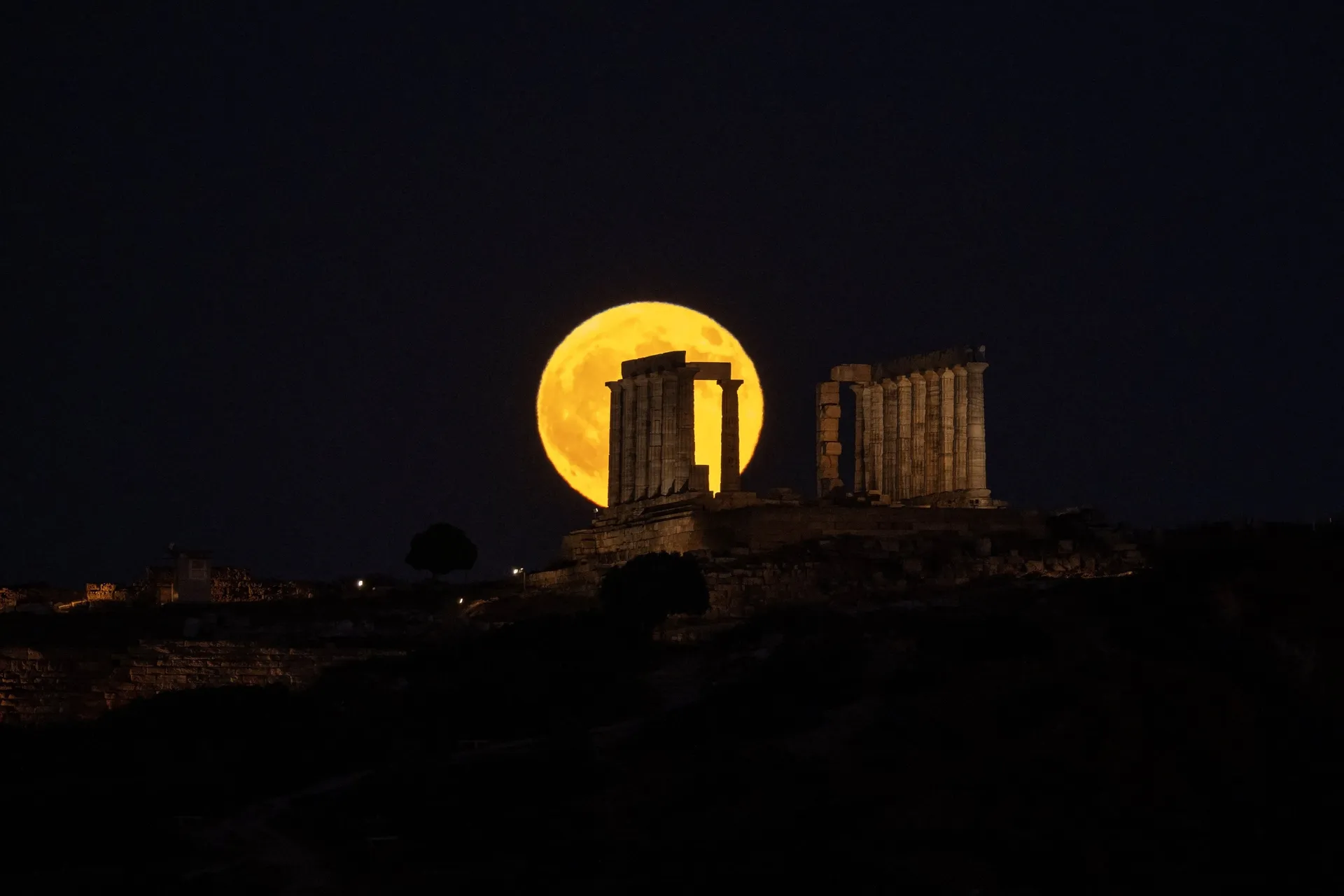 A full moon known as the "Buck Moon" rises behind the ancient Temple of Poseidon at Cape Sounion, south of in Athens, Greece, July 29, 2026. REUTERS/Louiza Vradi