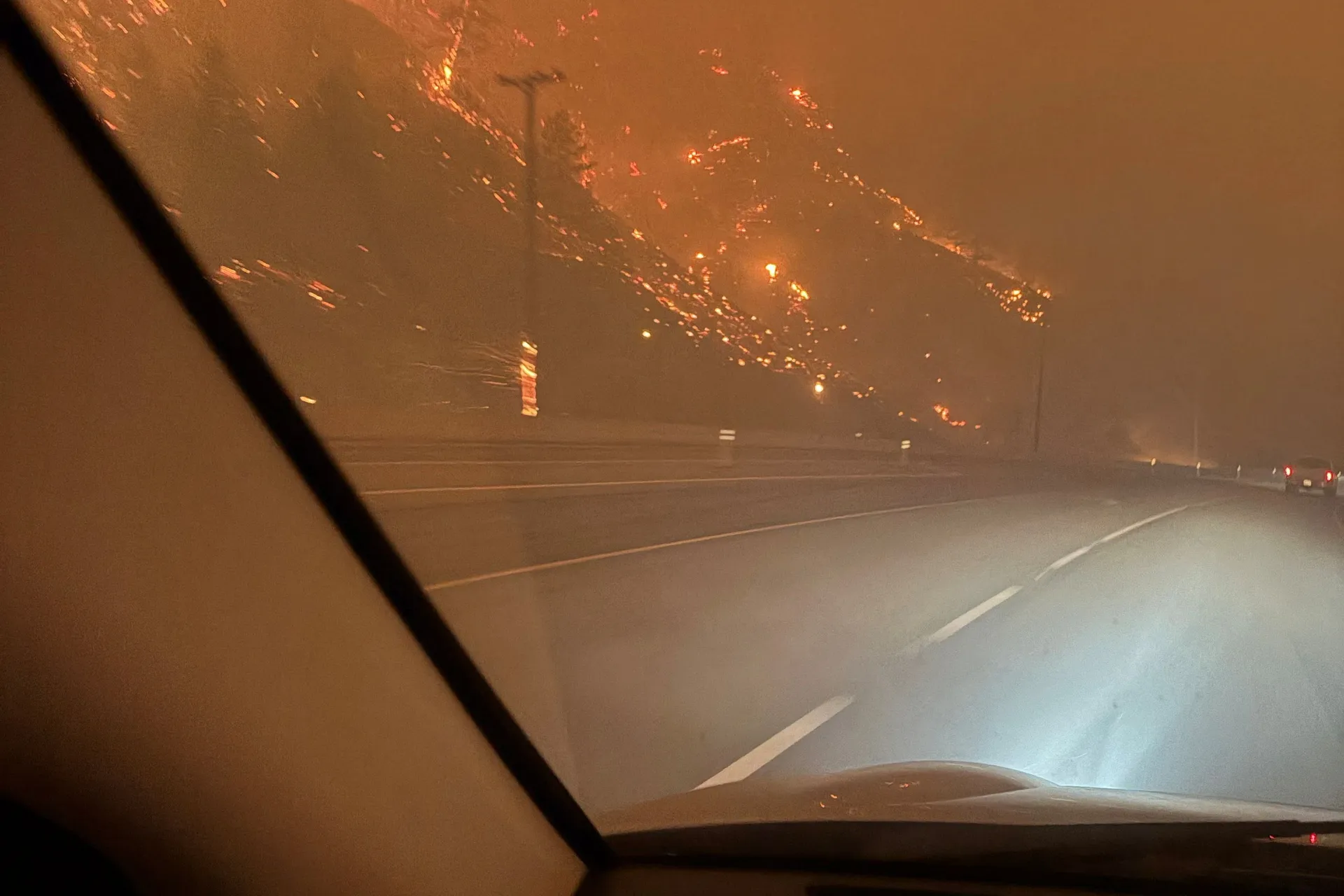 The hillside burns as residents evacuate towards Kelowna after midnight from the Bald Range wildfire along Highway 97 near Summerland, British Columbia, Canada August 8, 2026. Picture taken with a mobile phone. Terry Fries/Handout via REUTERS. THIS I