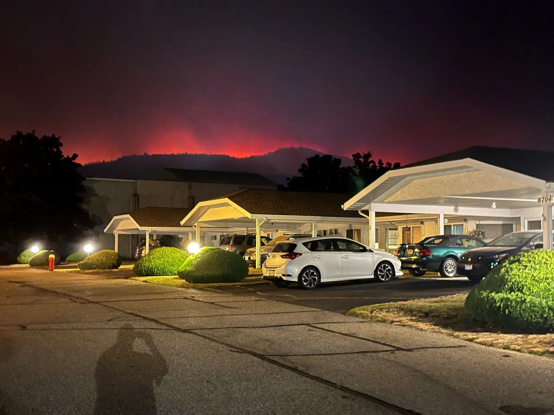 The Bald Range wildfire glows from behind hills near a residential street in Summerland, British Columbia, Canada, August 7, 2026. Picture taken with a mobile phone. Terry Fries/Handout via REUTERS. THIS IMAGE HAS BEEN SUPPLIED BY A THIRD PARTY. NO R