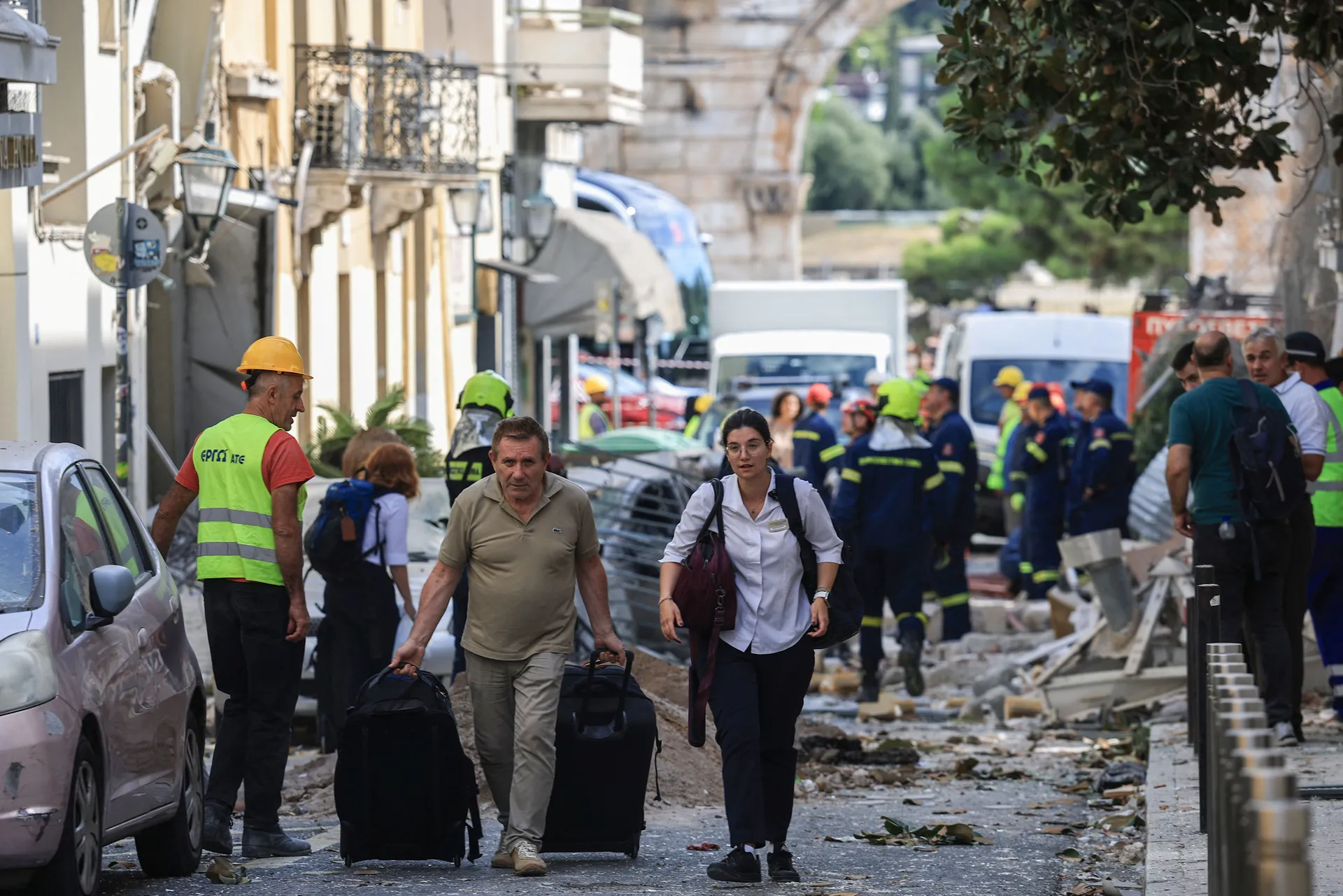 A member of staff moves a guest's bags from an from adjacent hotel, after a building partially collapsed following an explosion, in the Plaka area, which is popular with tourists, in central Athens, Greece, September 25, 2026. REUTERS/Louisa Gouliamaki