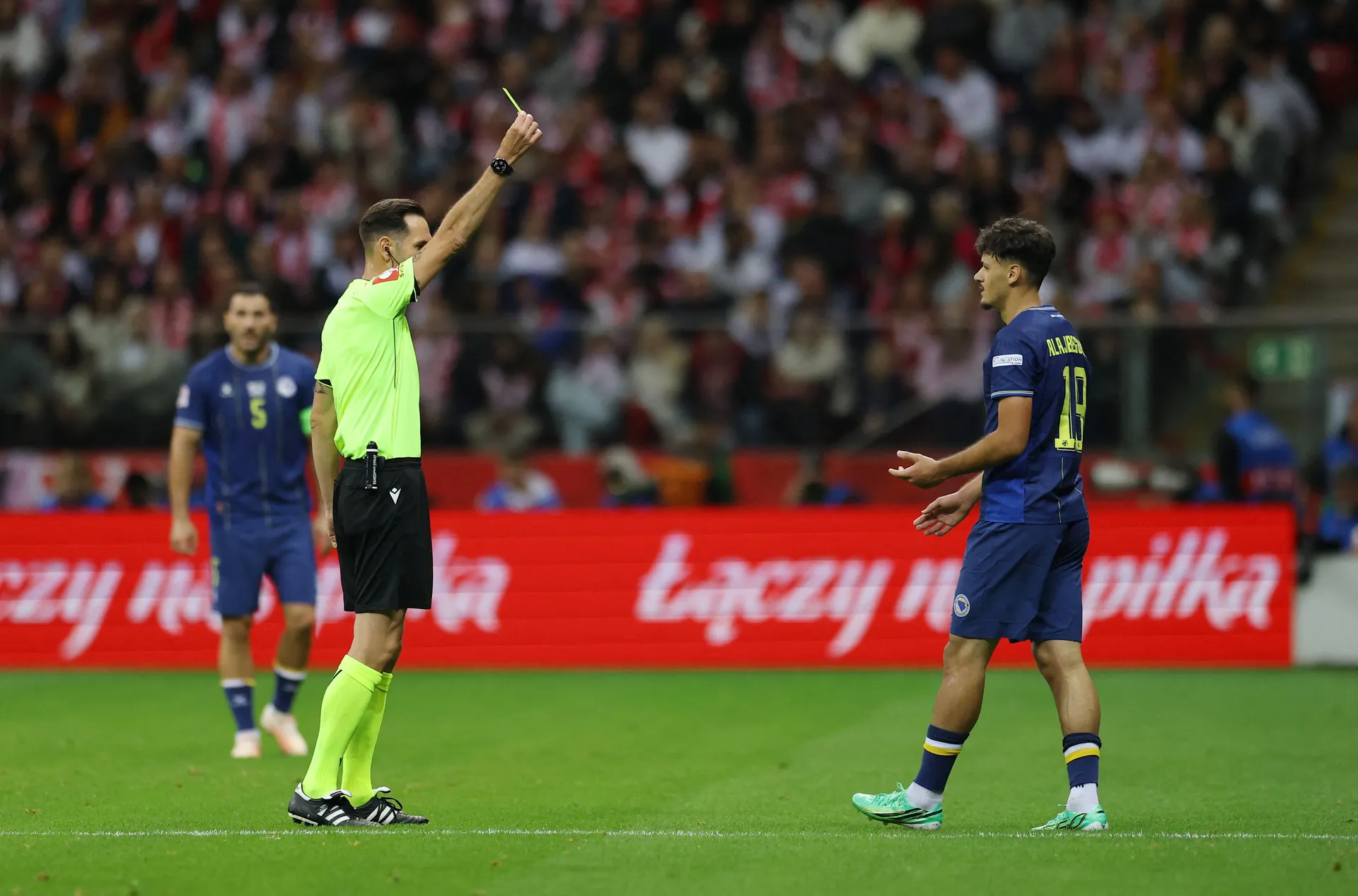 Soccer Football - Nations League - Group H - Poland v Bosnia and Herzegovina - PGE Narodowy, Warsaw, Poland - September 25, 2026 Bosnia and Herzegovina's Kerim Alajbegovic is shown a yellow card by referee Anastasios Papapetrou REUTERS/Kacper Pempel