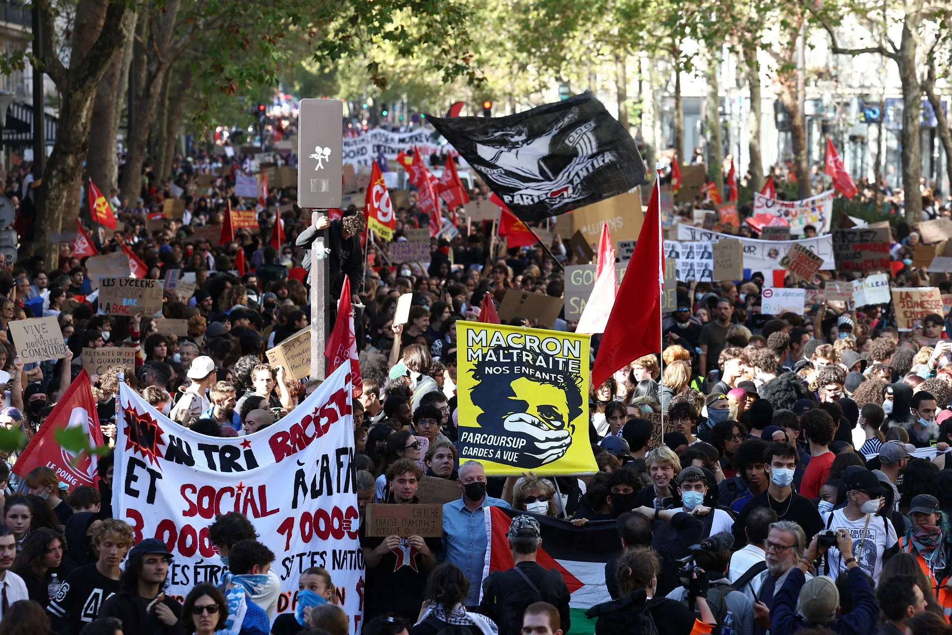 Protesters hold placards and flags during a demonstration by high school and university students, supported by teachers' union and school parents, in Paris as part of a nationwide day of protests and blockades, voicing anger over overcrowded classrooms, t