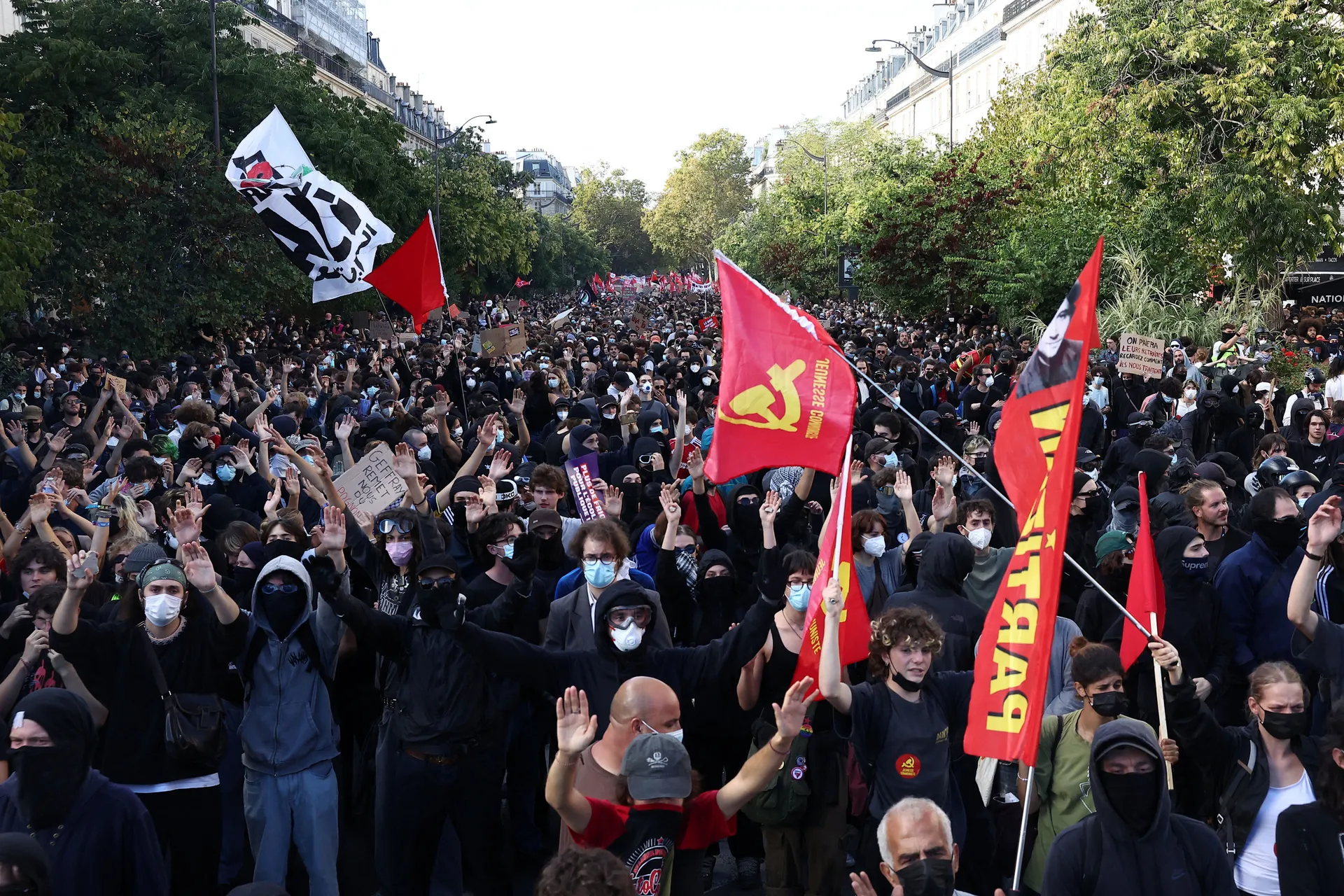 Protesters hold placards and flags during a demonstration by high school and university students, supported by teachers' union and school parents, in Paris as part of a nationwide day of protests and blockades, voicing anger over overcrowded classrooms, t