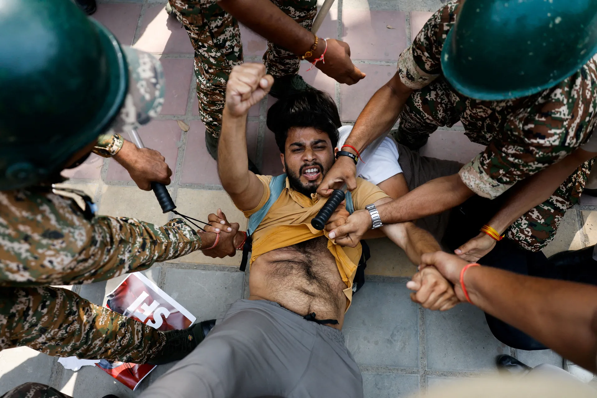 A protester gestures while being detained by security personnel during a protest by the Cockroach Janta Party (CJP) seeking the resignation of India's Chief Election Commissioner Gyanesh Kumar, near the protest site in New Delhi, India, October 10, 2026. 
