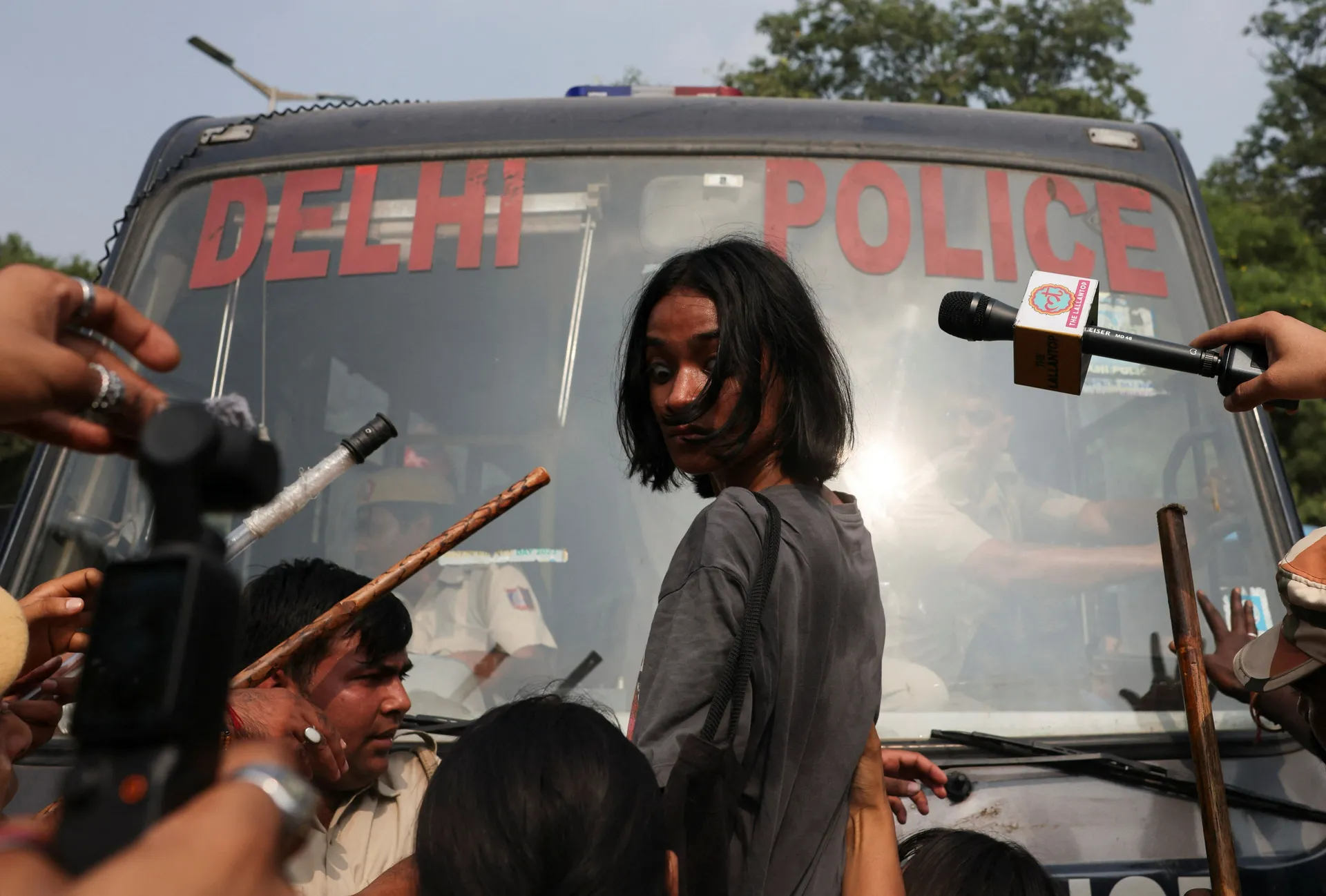A protester reacts as she tries to stop the police bus carrying detained protesters during a protest organised by the Cockroach Janta Party (CJP), seeking the resignation of India's Chief Election Commissioner, Gyanesh Kumar, in New Delhi, India, October 