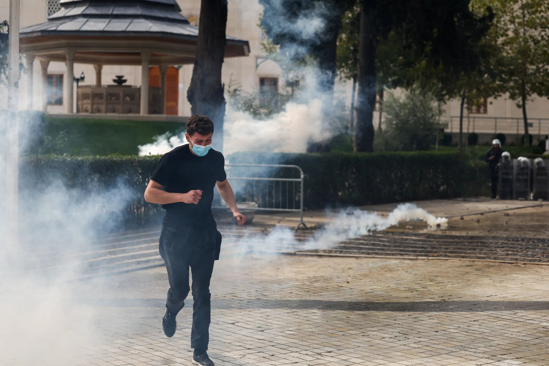 A man runs away from tear gas fired by police amid an anti-government protest by students, in Tirana, Albania, October 15, 2026. REUTERS/Florion Goga