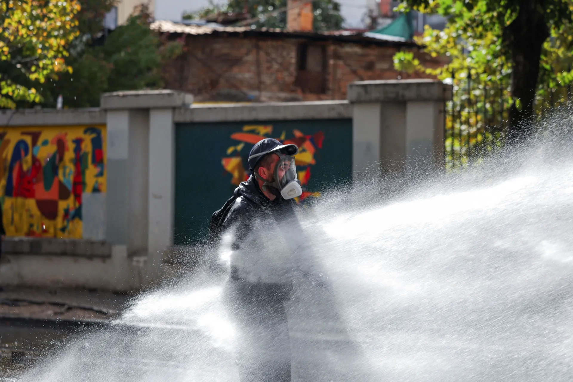 A demonstrator is sprayed with water during clashes with police amid an anti-government protest by students, in Tirana, Albania, October 15, 2026. REUTERS/Florion Goga