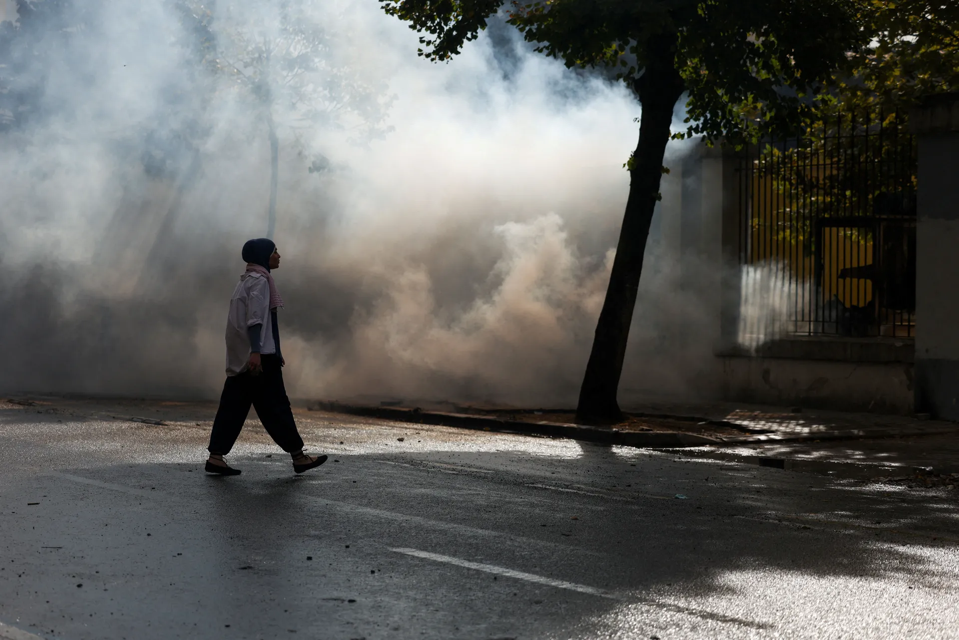 A demonstrator walks near tear gas fired by police amid an anti-government protest by students, in Tirana, Albania, October 15, 2026. REUTERS/Florion Goga     TPX IMAGES OF THE DAY