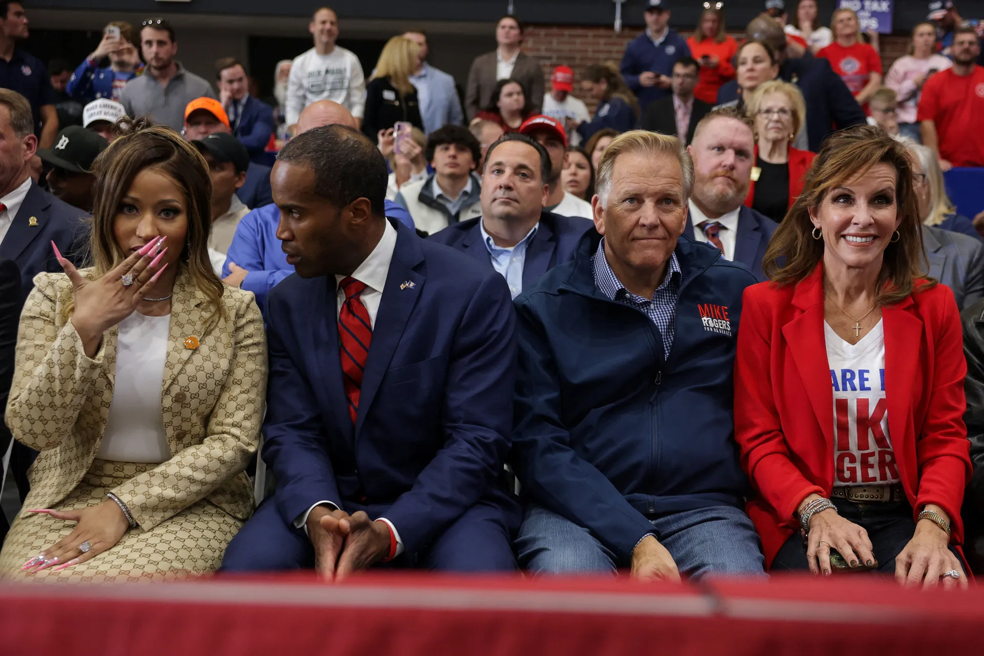 Republican US Senate candidate, former US Representative Mike Rogers sits with his wife, Kristi Clemens Rogers, Republican nominee for Michigan Governor, US Rep. John James (R-MI), recording artist Nicki Minaj, during a rally, ahead of the midterm electio