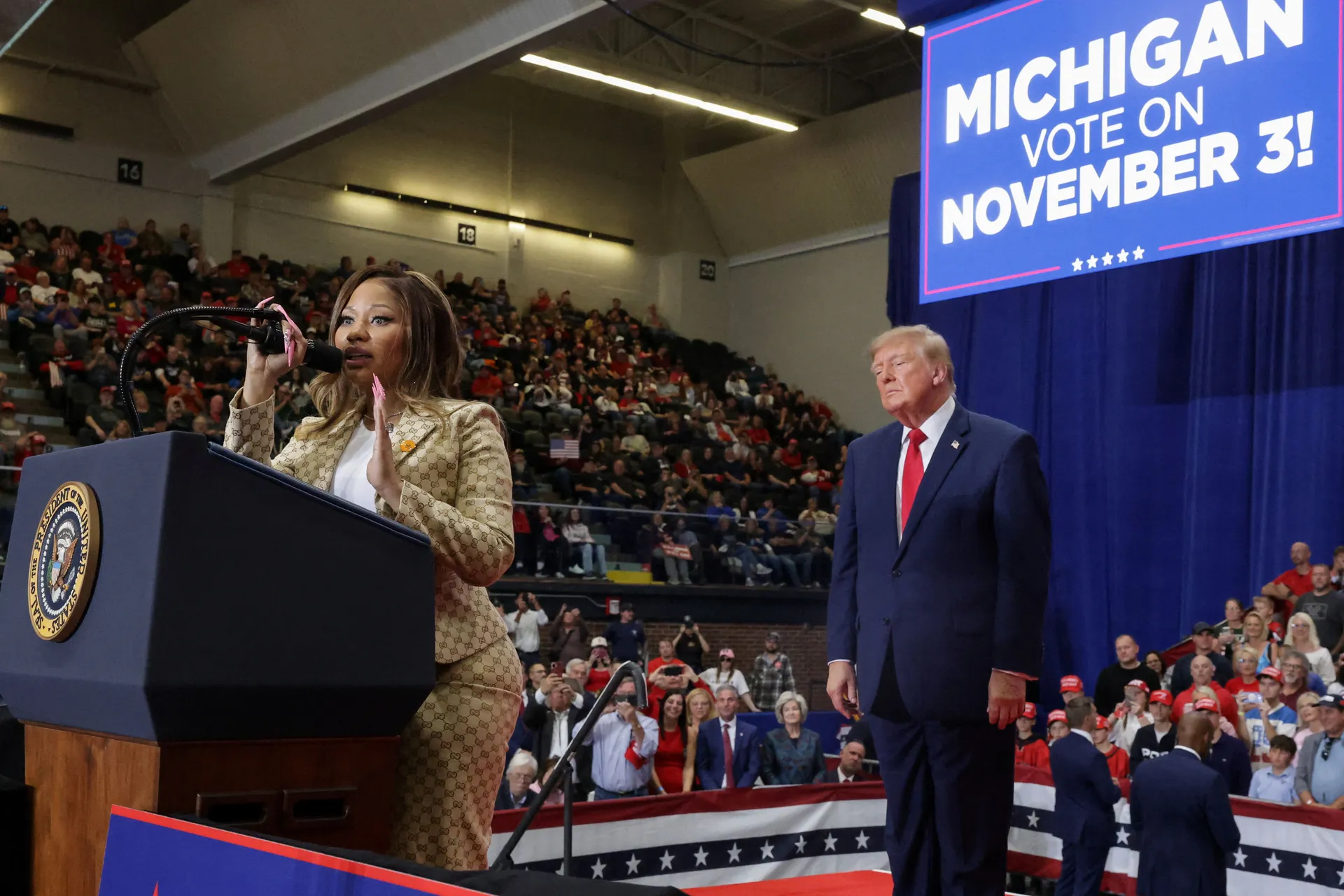 Recording artist Nicki Minaj speaks, as US President Donald Trump stands nearby, during a rally, in support of Republican US Senate candidate, former US Representative Mike Rogers, ahead of the midterm elections, at an entertainment complex in Port Huron,